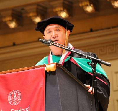 male speaking into microphone at podium