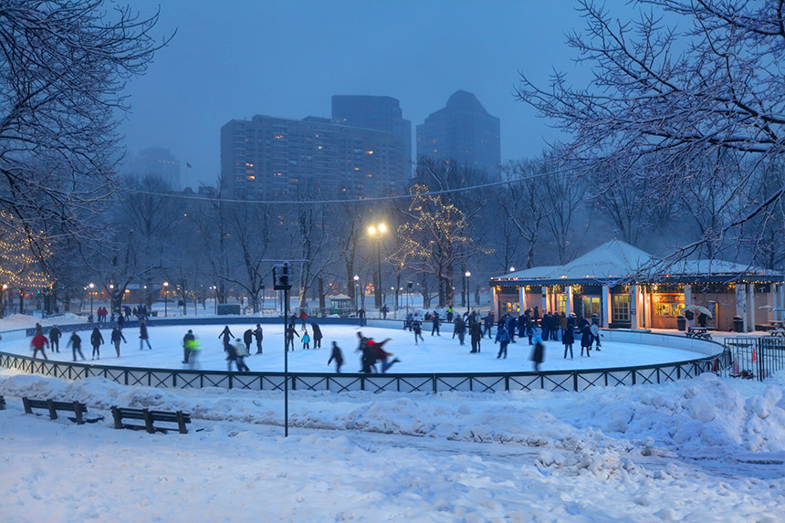 group of people ice skating the winter on frozen pond at night