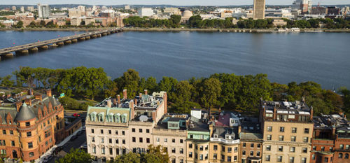 aerial picture of the beacon street building with the charles river behind it