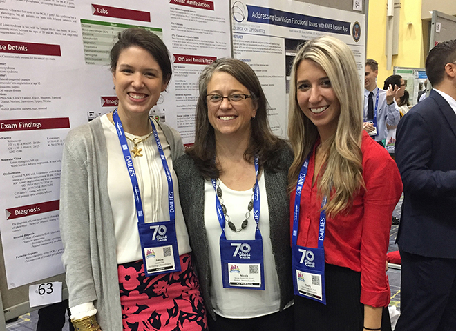 three students in front of their poster presentation at conference