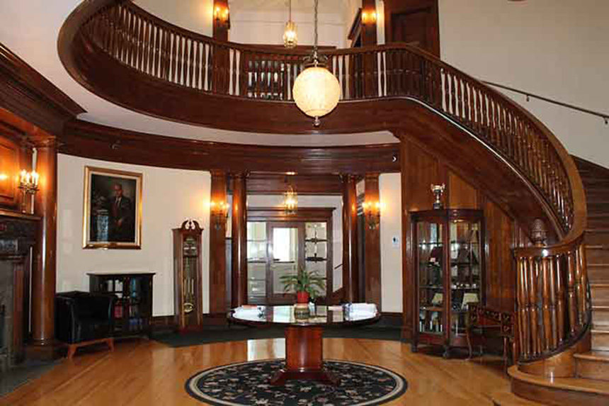 Rotunda entryway of round room with wood circular staircase.