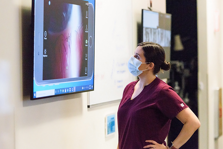 female doctor looking at large monitor with an image of a patient's big eyeball