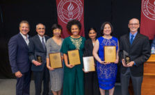 Group of award winners stand holding their plaques