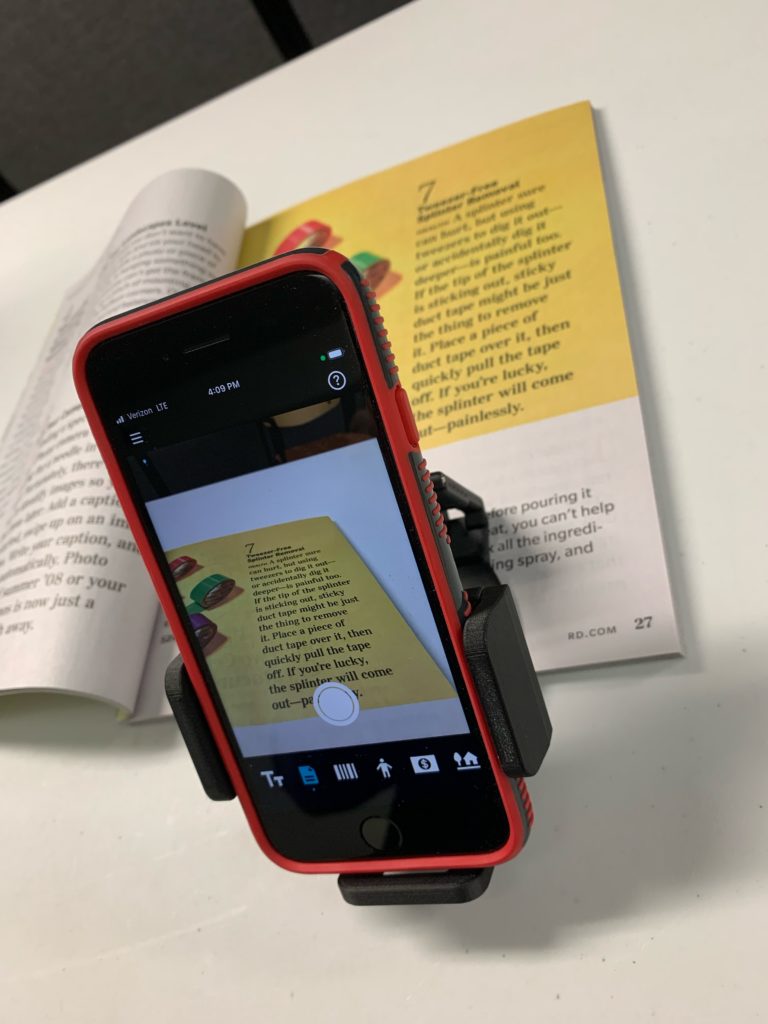 smartphone screen magnify text in a book 