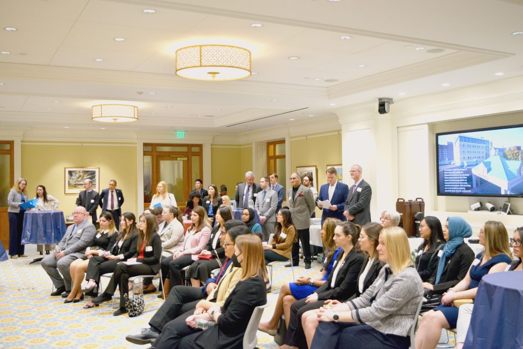 crowd sitting in formal room listening to speaker