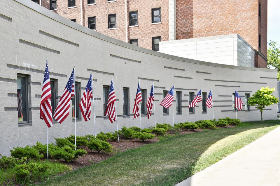 External white wall with american flags lined up in front
