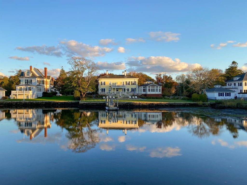 Sunset along the Mystic River in Mystic, Connecticut as reflections float above the still water.